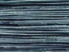 A stack of newspapers, seen from the side.