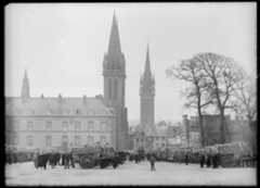 Sur la place charettes remplies de choux fleurs et paysans