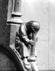 Accoudoir: personnage grotesque jouant de la trompe