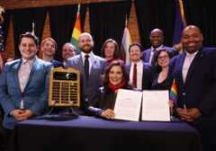 Gov. Whitmer, surrounded by Democratic legislators, after she signed the amendment to the Elliott-Larsen Civil Rights Act to protect LGBTQ+ Michiganders. Photo: State of Michigan