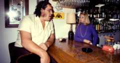 Andre the Giant sitting at a bar with a female bartender