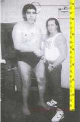 Andre the Gian with Bret Hart backstage and a ruler showing the height of both