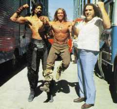 NBA basketball great Wilt Chamberlain and Andre the giant holding up Arnold Schwarzenegger in the air to show their strength on the set of Conan The Destroyer