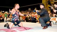 RVD drops to his knees in celebration in the ring as Paul Heyman hands him the WWE Championship after beating John Cena at ECW One Night Stand in 2006.
