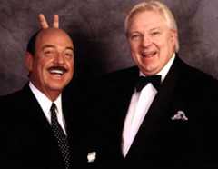 Mean Gene Okerlund and Bobby Heenan with Heenan giving Okerlund bunny ears behind his head