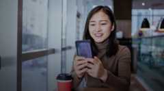 Young Asian woman using smart phone in coffee shop