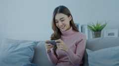 Woman playing mobile game at home