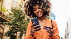 Happy Afro girl in Barcelona shopping online on the move