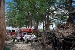President Donald Trump, first lady Melania Trump and Texas Gov. Greg Abbott meet with local emergency services personnel Friday as they survey flood damage along the Guadalupe River in Kerrville, Texas. (Chip Somodevilla/Getty Images)