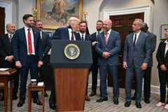 President Donald Trump checks out the biceps of WWE executive and former wrestler Triple H on Thursday at the White House.