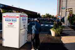 Voters use a District of Columbia Board of Elections mail-in-ballot drop box at Union Market in Washington on Oct. 5, 2020. 