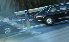 President Donald Trump waves to onlookers Saturday as the armored presidential Cadillac limousine returns to his Mar-a-Lago resort in Palm Beach, Fla. (Andrew Caballero-Reynolds/AFP via Getty Images)