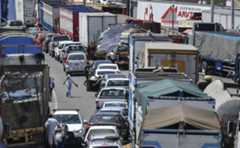 La gente camina a lo largo de un tramo de la Carretera Panamericana bloqueado por los camioneros que exigen la reducción de los costos de combustible a nivel nacional y la reducción de los pagos de peaje, cerca de la ciudad andina del sur de Arequipa, Perú, el 28 de marzo de 2022.