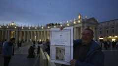 Un exemplaire du journal du Vatican "L'Osservatore Romano" sur la place Saint-Pierre, après une prière du rosaire pour le défunt pape François, le 21 avril 2025.