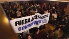 El Real Conservatorio Superior de Música de Madrid (RCSMM), dependiente de la Comunidad de Madrid, se convirtió este miércoles en el epicentro de un estallido social. La celebración del Acto Académico en honor a Santa Cecilia, patrona de la música, fue interrumpida por alumnos del Grupo Feminista que señalaron directamente a Pedro Garbajosa, catedrático de clarinete y profesor también de yogaterapia. El señalamiento se produjo en el momento en que Garbajosa, miembro del Cuadro de Honor, recibía una insignia por sus más de 20 años de dedicación al centro.Pese a los gritos de protesta de los estudiantes que clamaban "¡Fuera abusadores del conservatorio!", el profesor desoyó la interrupción, recogió la insignia y saludó al público con una larga reverencia antes de lanzar un beso.Las quejas de los estudiantes se han sucedido durante años en los pasillos del Conservatorio. Los testimonios recabados detallan prácticas cuestionables durante las clases individuales. Una alumna de clarinete, que solicitó el cambio de profesor (como "muchos que lo solicita curso tras curso"), relata la incomodidad de la experiencia: "Me abrazó por detrás y metió las manos bajo mis costillas. Dijo que era para controlar mi respiración, nunca antes un profesor me había tocado de esa manera". Ella describe la clase como un lugar "muy violento" donde "Estás sola con él en clase, imagínate".Otra estudiante recuerda haber dejado de asistir a las clases porque le hacía "sentir súper incómoda su forma de tocarme". Asegura que el profesor "Medía el tempo golpeando su mano contra mi pecho. Decía que sentía mejor el ritmo". A esto se suman comentarios de índole personal. "Me preguntó mi signo del zodíaco y dijo que tendríamos una relación muy turbulenta".El ambiente de clase se tornaba "muy violento, no sólo por sus comentarios sino también por su forma de humillarte". Un testimonio particularmente gráfico relata: "Cuando hacía algo bien, me decía: 'Ten cuidado, que se me empina'. Cuando hacía algo mal, me espetaba que no valía para nada, que era una mierda". Una de las estudiantes reconoció haber pensado en denunciarlo, pero "no lo hice por miedo" tras volverse agresivo al solicitar el cambio de docente.