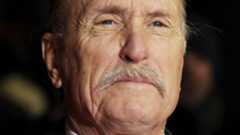 Hablar de Robert Duvall es evocar de inmediato una sucesión de títulos imprescindibles en la historia del cine. Su nombre remite a personajes inolvidables y a una carrera marcada por la versatilidad y la profundidad interpretativa. Fue el veterano policía al borde del retiro en Un día de furia, pero también el enigmático vecino recluido de Matar a un ruiseñor. Sin embargo, su leyenda se cimentó especialmente con papeles como el de Tom Hagen en las dos primeras entregas de El Padrino y el del teniente coronel Kilgore en Apocalypse Now, donde dejó escenas ya inscritas en la memoria colectiva.Integrante destacado de la generación que transformó Hollywood en los años setenta, Duvall demostró una asombrosa capacidad para la metamorfosis. Transitó con naturalidad por el drama, el thriller o el wéstern, siempre dotando a sus personajes de una humanidad compleja y creíble. Su talento parecía inagotable y su presencia en pantalla, magnética. Este lunes, su esposa confirmó su fallecimiento a los 95 años en su rancho de Virginia, poniendo fin a una de las trayectorias más admiradas del cine estadounidense.