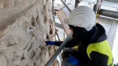 La capital italiana ha iniciado un ambicioso proyecto de conservación en uno de sus iconos más reconocibles. La Columna de Marco Aurelio, con 1.840 años de antigüedad, es uno de los monumentos más emblemáticos de Roma y actualmente es el centro de una intervención tecnológica sin precedentes. Este monumento, erigido originalmente para celebrar las gestas militares del emperador, está siendo intervenido mediante una moderna técnica basada en los rayos láser, un proceso que los expertos han definido como una especie de 'lifting' para devolver el lustre a una obra de arte de hace casi 2.000 años.Esta profunda restauración, que se puso en marcha la pasada primavera, no solo busca la limpieza del mármol, sino que ofrece una oportunidad casi única de encaramarse por los andamios para contemplar de cerca la narración que cuenta la piedra. Gracias a esta cercanía, es posible apreciar la maestría constructiva y la capacidad de propaganda política de la civilización romana, permitiendo una observación detallada que habitualmente es imposible desde el nivel del suelo.La estructura fue levantada a finales del siglo II después de Cristo por Cómodo, el hijo y sucesor de Marco Aurelio, con el fin de glorificar las campañas imperiales. Los relieves, que funcionan como si se tratara de una cinta que da 20 vueltas alrededor de la columna, relatan de forma épica las victorias de Marco Aurelio ante los germanos y los sármatas. La minuciosidad del trabajo escultórico es tal que no faltan los detalles: los visitantes que acceden a los andamios pueden ver desde la figura divinizada del emperador hasta el horror de la guerra, representado en las cabezas cortadas de los enemigos y los rostros desesperados de los pueblos vencidos.Además de la violencia de las batallas, la obra destaca por la representación de las imponentes armaduras de los legionarios, un testimonio visual del poder militar de la Antigua Roma. En definitiva, esta restauración con láser permite que la grandeza de la antigüedad se aprecie mejor que nunca, situando al espectador a pocos centímetros de un mármol que ha sobrevivido a casi dos milenios de historia.Esta restauración actúa como un puente temporal: el láser moderno elimina las capas de contaminación y el paso del tiempo de la misma forma que un restaurador experto retira el polvo de un manuscrito antiguo, revelando la tinta original y devolviendo la voz a una historia que se negaba a ser olvidada.