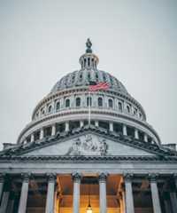 Image of the United States capitol building with the American flag flying in front.