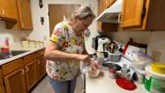Jackie Baker makes lunch in her kitchen. (Melissa Krull/Spectrum News 1)