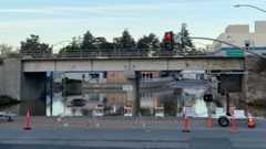 Road closed and car trapped in flooded street under highway underpass