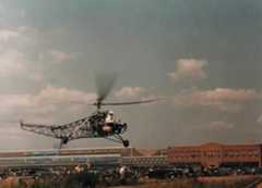 A rare color photo of Igor Sikorsky in the VS-300 hovering over meadow across from the factory.