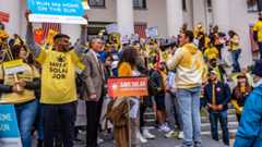 A large group holding solar signs smiling and advocating for solar.