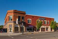 2-story brick commercial building with corner entrance. 2 lower level windows arched stone.