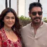 Mrunal Thakur with a glamour red fit pose with co star Ajay Devgn