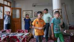 Shirin Yakubov visiting the main synagogue of Bukhara, Uzbekistan, with her son, in orange shirt, his friend and the site's two Muslim caretakers, September 9, 2016. (Cnaan Liphshiz/JTA) 