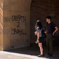 Students walk by graffiti saying 'Death to Israel' near the office of the President at Stanford University in Palo Alto, California, June 5, 2024. (AP Photo/Nic Coury)
