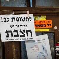 A notice warning of measles is seen on a door in the ultra-Orthodox neighborhood of Mea Shearim in Jerusalem, July 31, 2025. (Chaim Goldberg/Flash90)