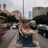 Cars speed past a roadside statue depicting the Virgin Mary holding the body of Jesus, in Beirut, Lebanon, November 13, 2025. (Hassan Ammar/AP)