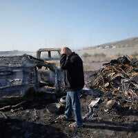 Mohammad Dalal looks at scorched cars in his scrapyard that was set ablaze the night before by who local residents alleged were Israeli settlers in the town of Huwara near the West Bank city of Nablus, Friday, Nov. 21, 2025. (AP Photo/Nasser Nasser)