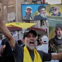 A Hezbollah supporter shouts slogans as he carries a portrait of the terror group's military chief of staff, Haytham AliTabatabai, during his funeral procession with two other Hezbollah members who were killed a day earlier in an Israeli airstrike in the southern suburb of Beirut, Lebanon, November 24, 2025. (AP Photo/ Hussein Malla)