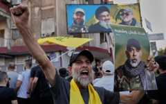 A Hezbollah supporter shouts slogans as he carries a portrait of the terror group's military chief of staff, Haytham AliTabatabai, during his funeral procession with two other Hezbollah members who were killed a day earlier in an Israeli airstrike in the southern suburb of Beirut, Lebanon, November 24, 2025. (AP Photo/ Hussein Malla)