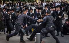 Police detain an ultra-Orthodox man during a protest against Haredi enlistment to the IDF outside a military recruitment center in Jerusalem, November 12, 2025. (Chaim Goldberg/Flash90)