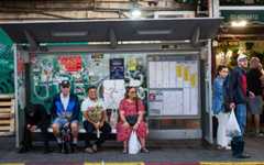 Illustrative: People wait at a bus station outside the Mahane Yehuda market in Jerusalem on November 13, 2025. (Nati Shohat/Flash90)