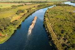 Embarcação com carga em meio a hidrovia.