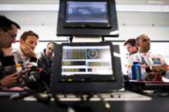 British McLaren Formula One team racing driver Jenson Button (L) reviews telemetry data from his MP4-27 racing car with his British engineer Tom Stallard (third from L) while his teammate Lewis Hamilton (R) gesticulates with a hand gesture while in conversation with his engineer as they all stand around the McLaren pit lane, pit garage data displaying computer and television monitors desk during practice for the 2012 Chinese Grand Prix, Shanghai International Circuit, Shanghai, China, on the 13th April 2012. (Photo by Darren Heath/Getty Images)