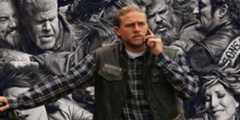 Jax in the Sons of Anarchy finale in front of a promo image for the series.