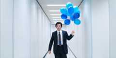 Mark Scout (Adam Scott) holding blue balloons in a hallway on Severance
