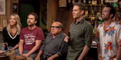 The Paddy's Pub gang smiling in the bar in  It's Always Sunny in Philadelphia