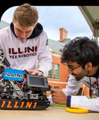 Two students working on a robot on a tabletop