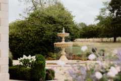 bride and groom embracing each other in field, sky is gold