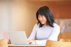 A photo of a woman using a laptop.