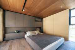 寝室も居心地良い空間。床から天井までのフルハイトサッシで、自然光も優しく取り入れられる（写真撮影／中川千代美）