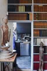 キッチンとリビングを仕切る壁は、全面が本棚。キッチン側の壁は食材の棚になっている（撮影／Manabu Matsunaga）