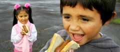 Children enjoy a sausage sizzle at Prospect School in Auckland, 2008