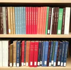 A colour photograph of two shelves of multi-coloured hardcover books.