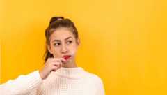 A girl in white sweater brushing her teeth.